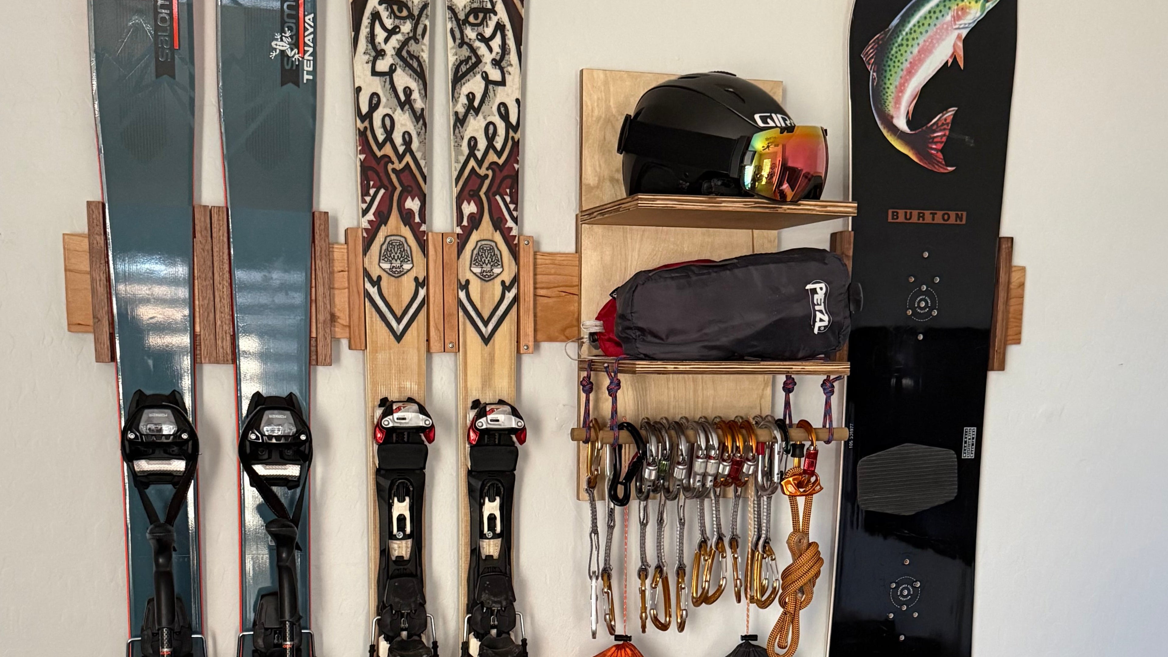 Collection of skis and ski equipment on solid wood ski and snowboard racks.